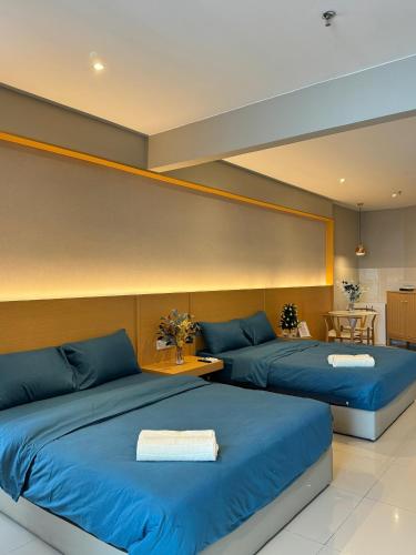 dwa łóżka w pokoju z niebieską pościelą w obiekcie Cozysuite Seaview-The shore w mieście Kota Kinabalu
