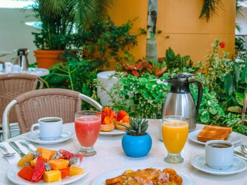 科苏梅尔Hotel Casa Mexicana Cozumel的桌上放有水果和果汁