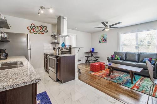 a living room with a couch and a kitchen at Near OU Medical Bricktown an Artist Apartment in Oklahoma City