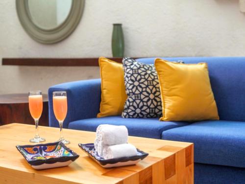a blue couch with two champagne glasses on a table at Hotel Casa Mexicana Cozumel in Cozumel