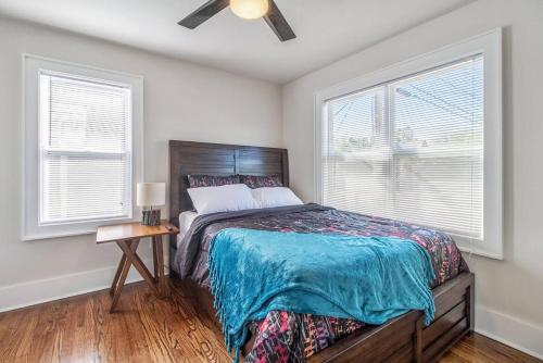 a bedroom with a bed and two windows at Near OU Medical Bricktown an Artist Apartment in Oklahoma City