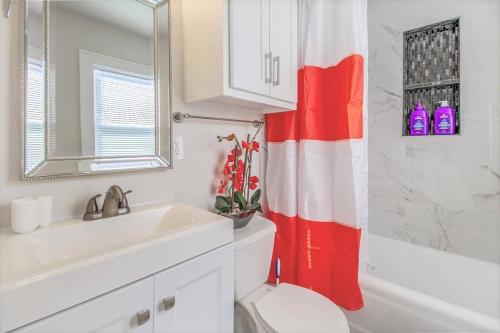 a bathroom with a red and white shower curtain at Near OU Medical Bricktown an Artist Apartment in Oklahoma City