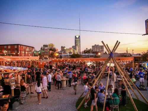 a crowd of people at a market with a city in the background at Near OU Medical Bricktown an Artist Apartment in Oklahoma City