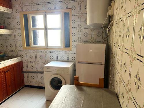 cocina con lavadora y ventana en Abdallah Appartement, en Essaouira