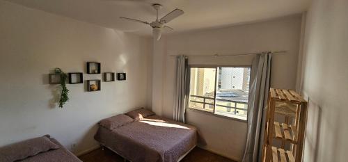 a small bedroom with a bed and a window at Centro Guarapari - espaço & conforto - WI-FI in Guarapari