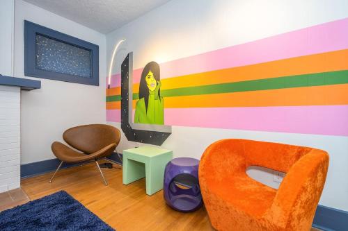a room with an orange chair and a colorful wall at Mural studio-near Plaza District in Oklahoma City