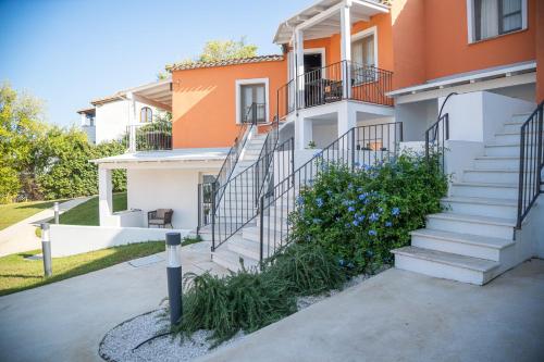 a building with stairs and flowers in front of it at Felix Hotels - Galanias Hotel & Retreat in Bari Sardo