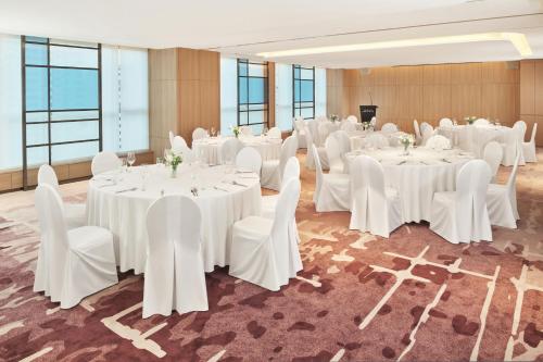 a room with white tables and white chairs and tablesearcher at The Link Seoul, a Tribute Portfolio Hotel in Seoul