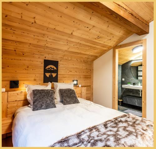 1 dormitorio con cama blanca grande en el techo de madera en Le Grand Condor I Duplex I Morzine, en Morzine