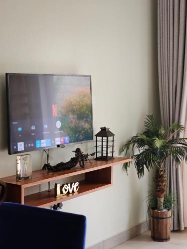 a flat screen tv sitting on top of a wooden shelf at Alsander Homes Peach in Bweyogerere