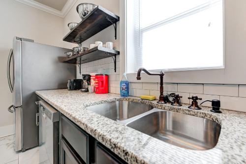 a kitchen with a sink and a refrigerator at Howes Capitol I - Sleek & stylish walk to OU Med in Oklahoma City