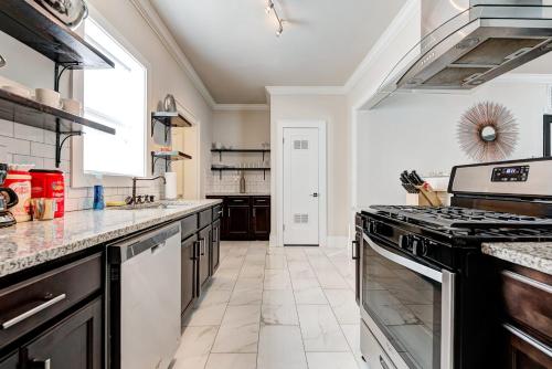 a kitchen with black and white appliances and a window at Howes Capitol I - Sleek & stylish walk to OU Med in Oklahoma City