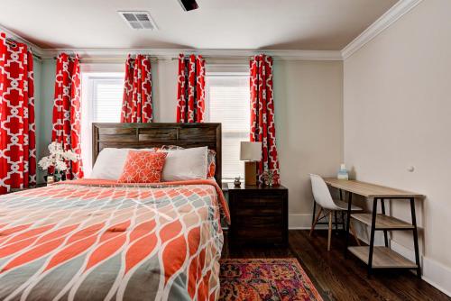 a bedroom with red curtains and a bed and a desk at Howes Capitol I - Sleek & stylish walk to OU Med in Oklahoma City
