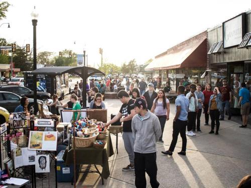 a group of people standing on a sidewalk in a market at Howes Capitol I - Sleek & stylish walk to OU Med in Oklahoma City