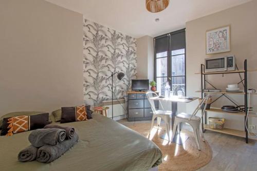 une chambre avec un lit, un bureau et une table dans l'établissement La républicaine, à Brive-la-Gaillarde