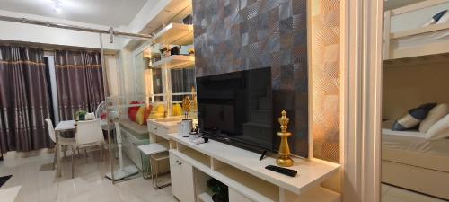 un salon avec une télévision sur un comptoir dans l'établissement The Cozy Rosy - SMDC Winds Staycation, à Tagaytay