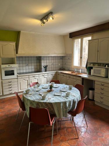 une cuisine avec une table et des chaises dans l'établissement Appartement 6 Chambres Coeur de Ville, à Soissons