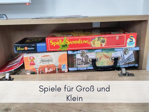 a shelf with a bunch of games and books at Komfort FeWo l Moselstay l maximal 4 Personen und Baby I Brauneberg Mosel I WIFI I in Brauneberg