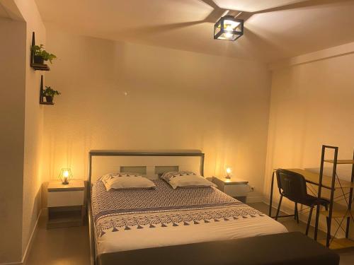 une chambre avec un lit avec deux tables et deux lampes dans l'établissement Grand T2 centre-ville, calme, lumineux et spacieux, 1 chambre, 1 à 5 pers, climatisation, wifi, parking libre et gratuit, à Lorient
