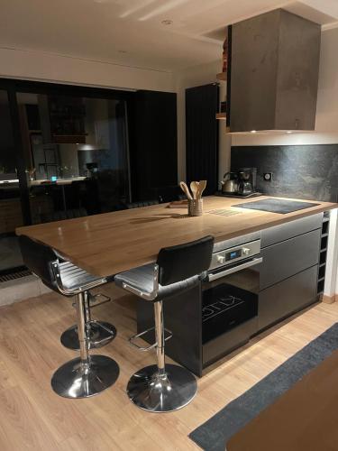 - une cuisine avec une table en bois et deux tabourets de bar dans l'établissement Appt 602, à Colmar