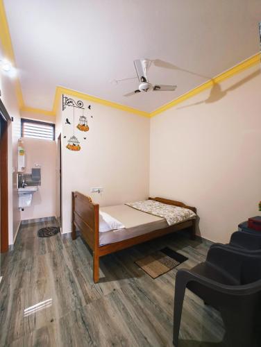 a small room with a bed and a ceiling at Nellakki Homestay in Madikeri