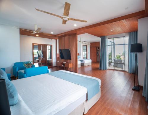 a bedroom with a bed and a living room at Araamu Hotels Maldives at Dhiffushi in Dhiffushi