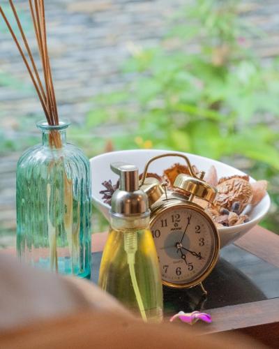 a clock sitting on a table next to a bowl of food at Araamu Hotels Maldives at Dhiffushi in Dhiffushi