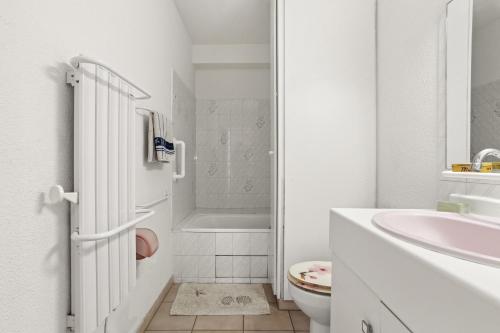 Un baño blanco con lavabo e inodoro. en Appartement à 200 M De La Mer, en Fréjus