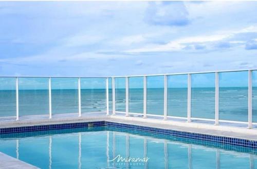 a swimming pool with a view of the ocean at Blue Premium em Cabo Branco Beira Mar in João Pessoa