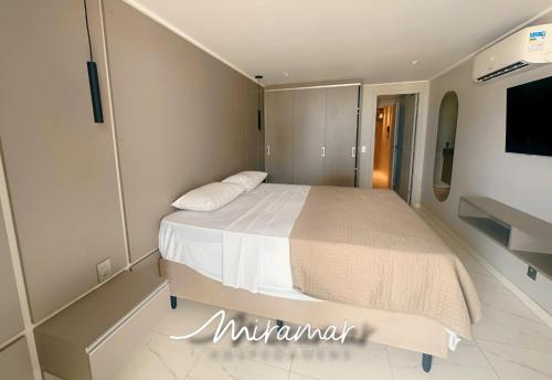 a bedroom with a large bed and a tv at Blue Premium em Cabo Branco Beira Mar in João Pessoa