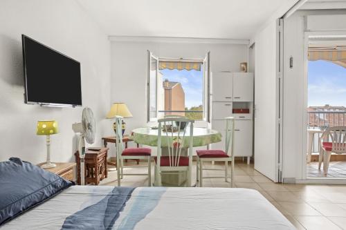 Un dormitorio con una cama y un comedor con una mesa. en Appartement à 200 M De La Mer, en Fréjus