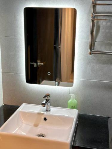 a bathroom sink with a mirror and a soap dispenser at URBAN Suites Modern Pinky 6pax 3queen 3Bedroom 2Bathroom 2Carpark with Infinity Pool in Jelutong