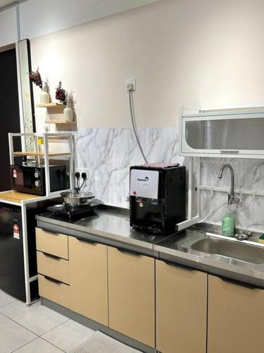 a kitchen with a sink and a microwave at URBAN Suites Modern Pinky 6pax 3queen 3Bedroom 2Bathroom 2Carpark with Infinity Pool in Jelutong
