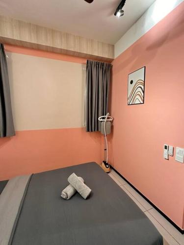 a room with a bed with two towels on it at URBAN Suites Modern Pinky 6pax 3queen 3Bedroom 2Bathroom 2Carpark with Infinity Pool in Jelutong