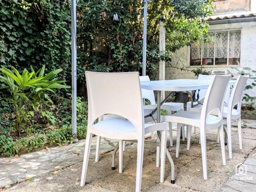 - une table et des chaises blanches dans le jardin dans l'établissement Maison 3 ch - Terrasse - Parking, à Saint-Jean-de-la-Ruelle