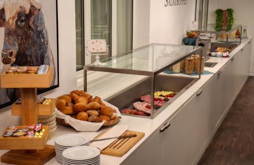 a bakery counter with bread and other food items at Hotel Alpina in Schiers