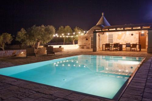 ein Schwimmbad in einem Garten in der Nacht in der Unterkunft Trullo Oasi Santo Stefano - private pool in Castellana Grotte