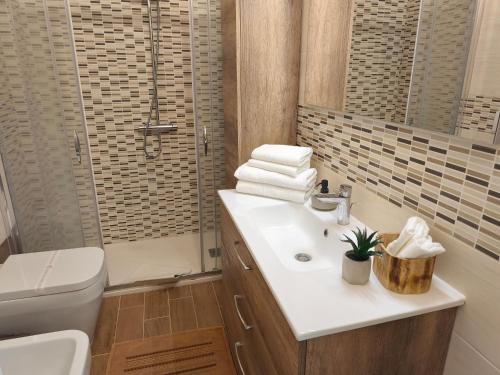 Un baño con lavabo, inodoro y ducha. en Guest House Civico 16, en Oristano