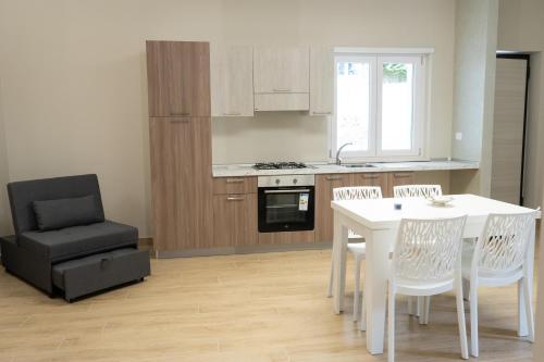 a kitchen with a white table and a black chair at Moon Valley Holiday Home in Lauria