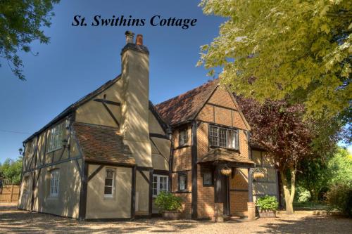 an old house with a chimney with the words st swiths cottage at Huge Cottage for Sophisticated Hen Party and Large Groups in Hurst