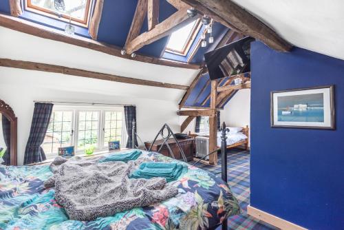 a bedroom with a bed and a blue wall at Huge Cottage for Sophisticated Hen Party and Large Groups in Hurst