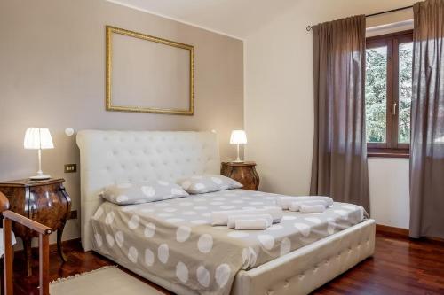 a bedroom with a white bed with two lamps and a window at Casa Vacanze Emmanuele in Porano