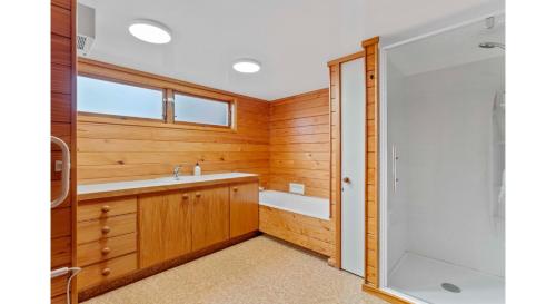 a bathroom with a shower and a sink at Lakefront Retreat - Lake Taupo Holiday Home in Turangi