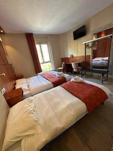 a hotel room with two beds and a piano at Hôtel Victoria in Reims
