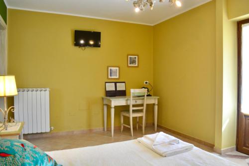 a bedroom with a desk and a bed with a computer at Agriturismo Colle Mura in Morano Madonnuccia
