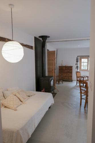 - une chambre avec un lit et un poêle à bois dans l'établissement Haixpia, Le Gîte, à Hasparren