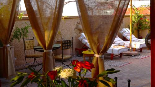 un patio avec un tas de chaises et une table avec des fleurs dans l'établissement Riad Agdal Royal & Spa, à Marrakech