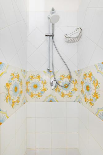 a shower in a bathroom with a tile wall at Il Merlo Capri in Capri
