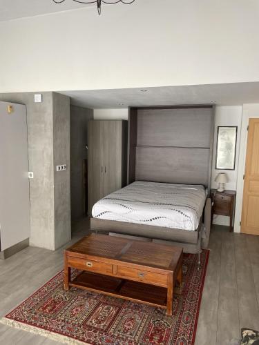 - une chambre avec un lit et une table basse dans l'établissement Loft 45m2 Piscine, à Carqueiranne