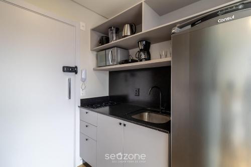 a kitchen with a sink and a refrigerator at RUP - Studios Equipados em Prédio com Piscina in Blumenau